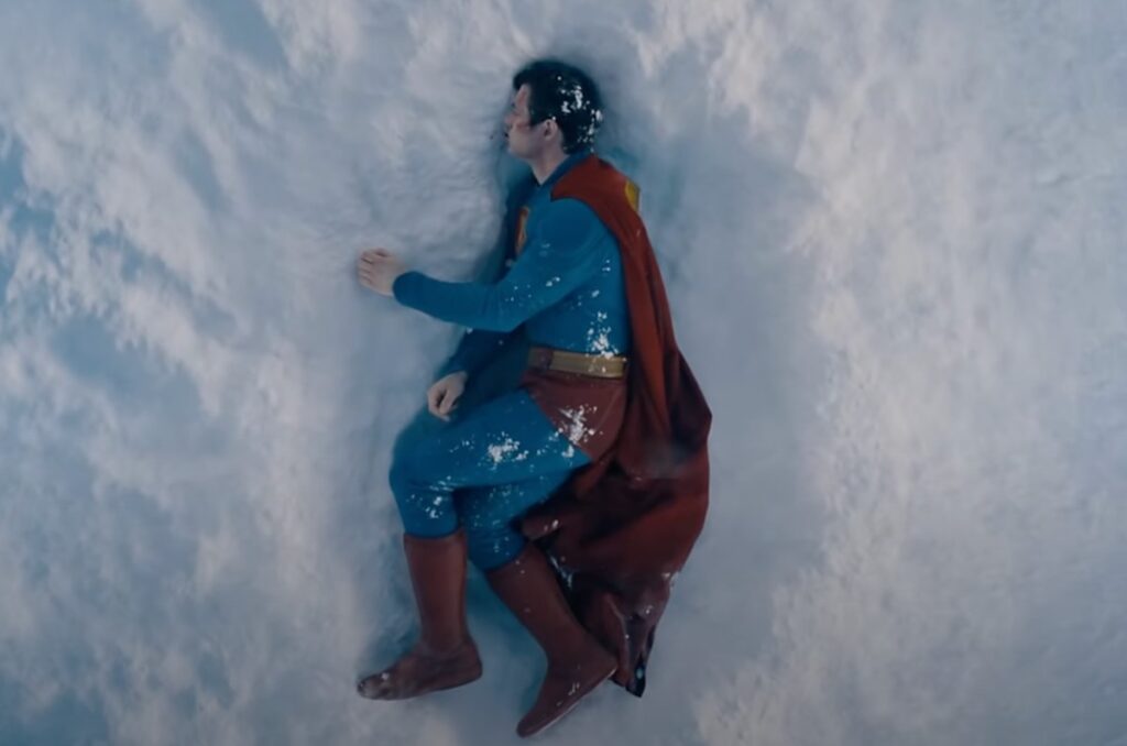 Superman lying on his side in a snow drift, bleeding rom his nose and mouth.