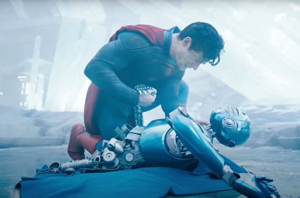 Superman kneeling over the body of a robot.