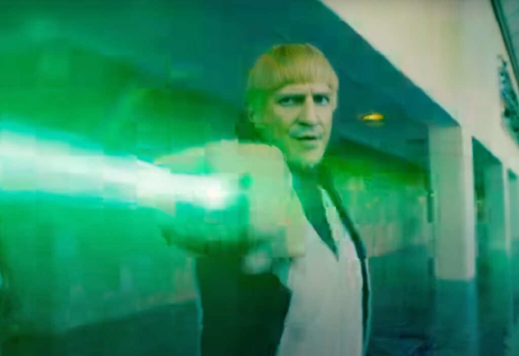 Blond man with bowl haircut shooting green laser light.