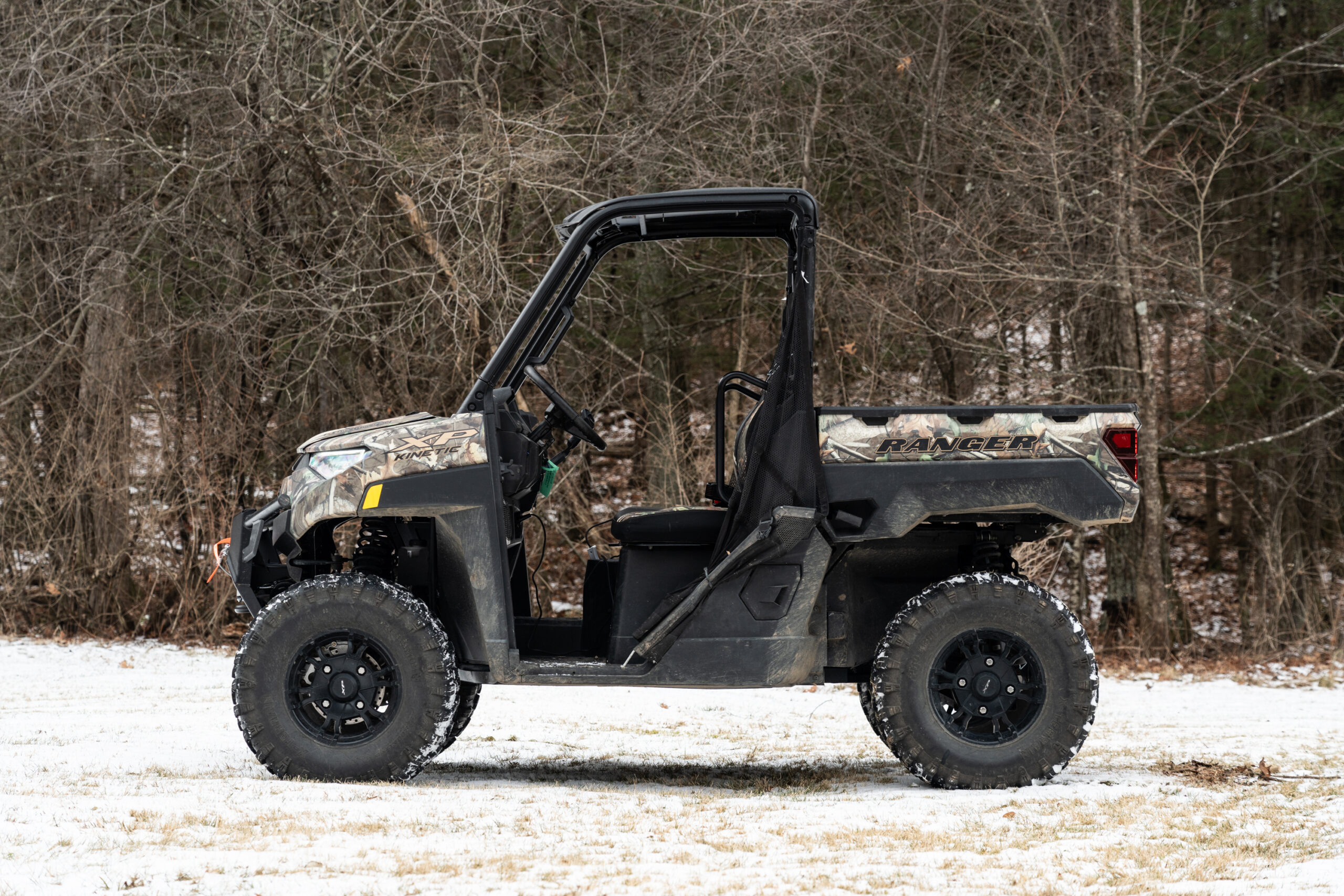 A Polaris electric side by side seen from the side, in the snow.