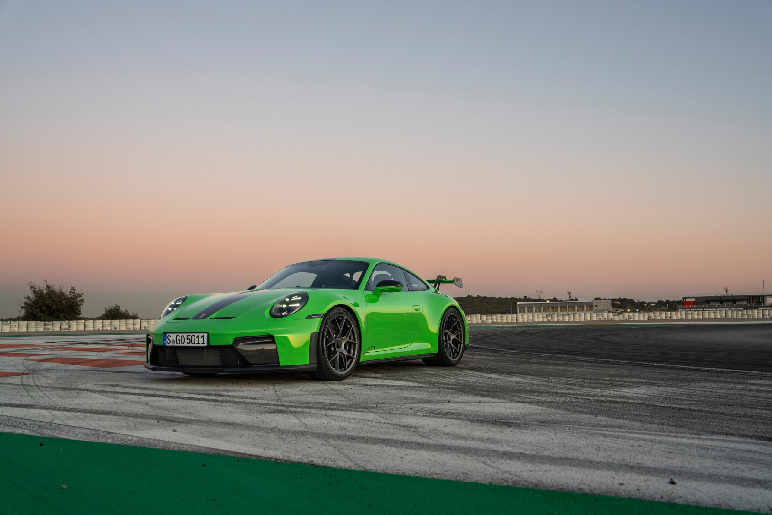 A green Porsche 911 GT3 seen at sunset