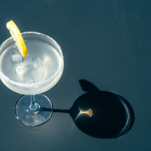 Glass with margarita cocktail on the table in a sunny day.