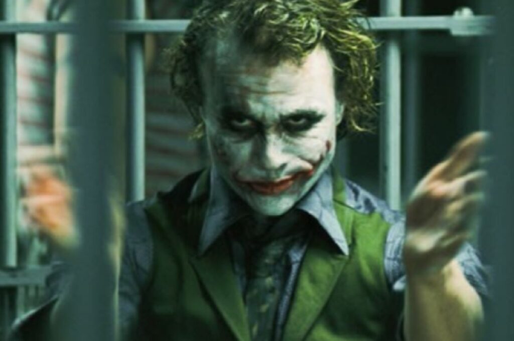 Joker in a jail cell doing a mocking slow clap