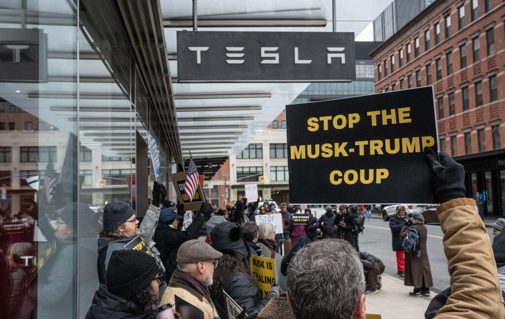 Protesters gathered outside Tesla showrooms across the US on Saturday to demonstrate against the drastic cuts Elon Musk, the billionaire adviser to Pr