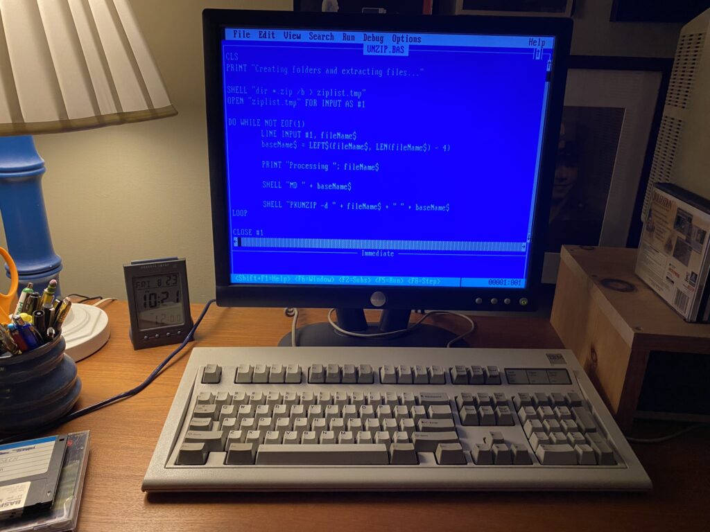 A photo of a MS-DOS computer with Q-BASIC code on the screen.