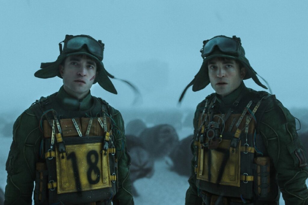 Identical Robert Pattinson's in matching outfits standing on icy terrain