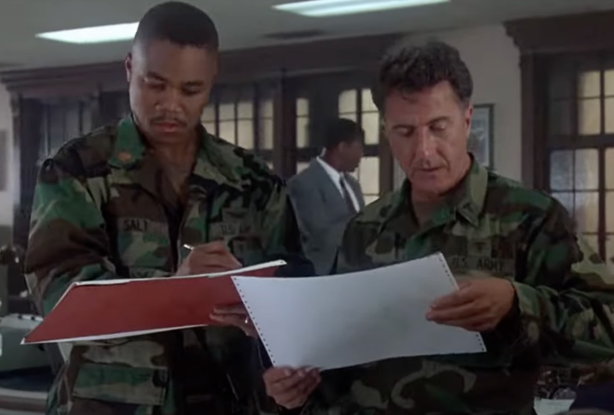 two men in military garb looking intently at papers