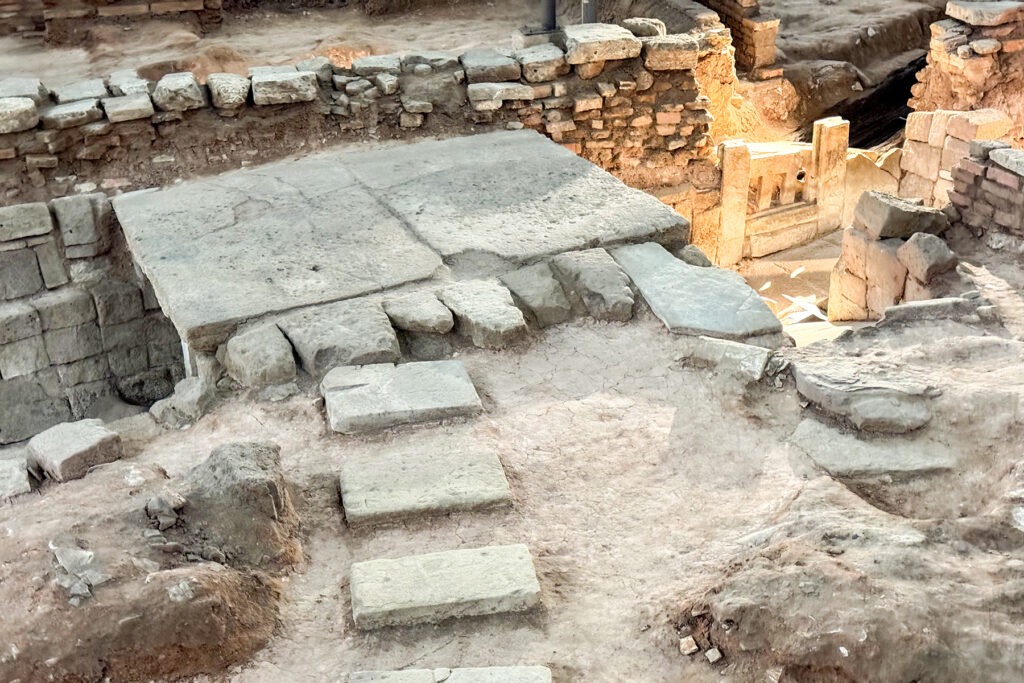 photo of an archaeological site, with the remains of stone walls and steps.