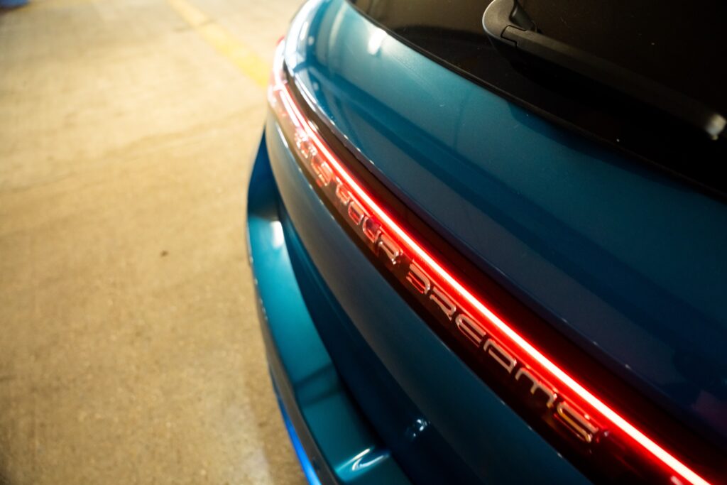 the rear illuminated logo of a BYD Dolphin, which says BUILD YOUR DREAMS