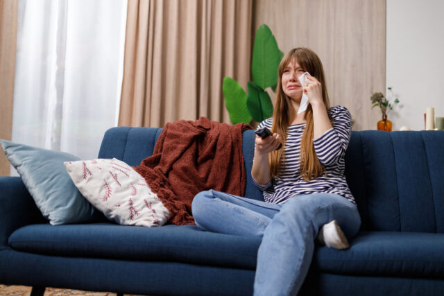 woman watching television and crying