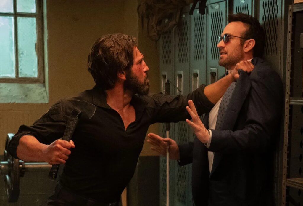 Bearded man holding a blind man against the wall with a fist poised to strike