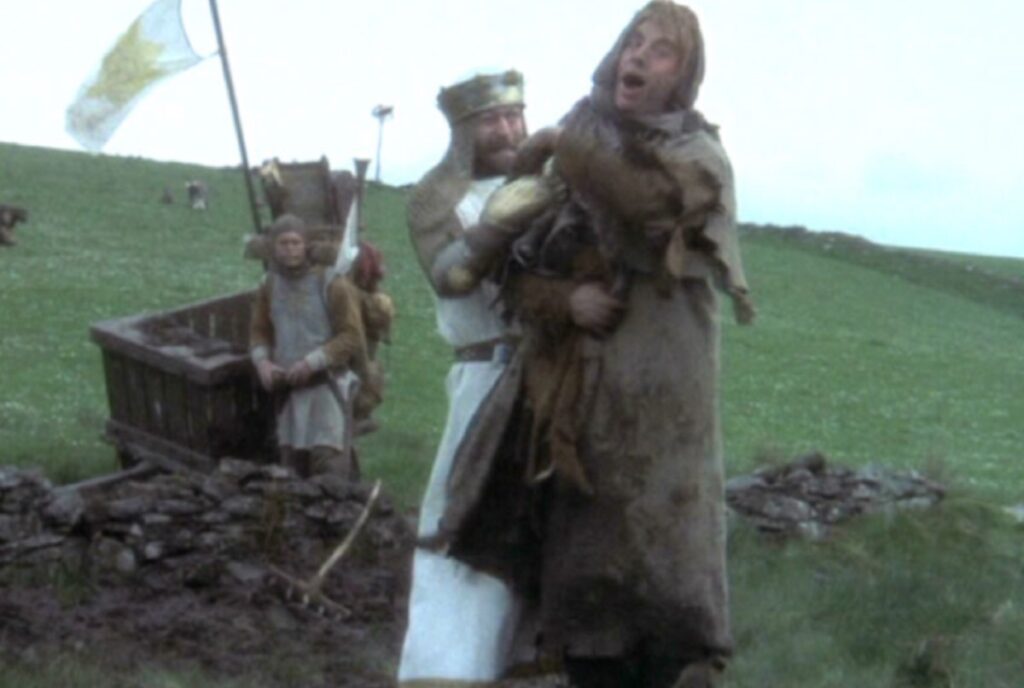 King Arthur attempting to throttle a peasant in the field