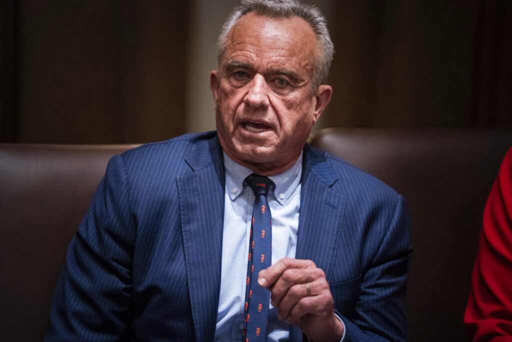 Robert F. Kennedy Jr. speaks while sitting and gesturing with his hand.