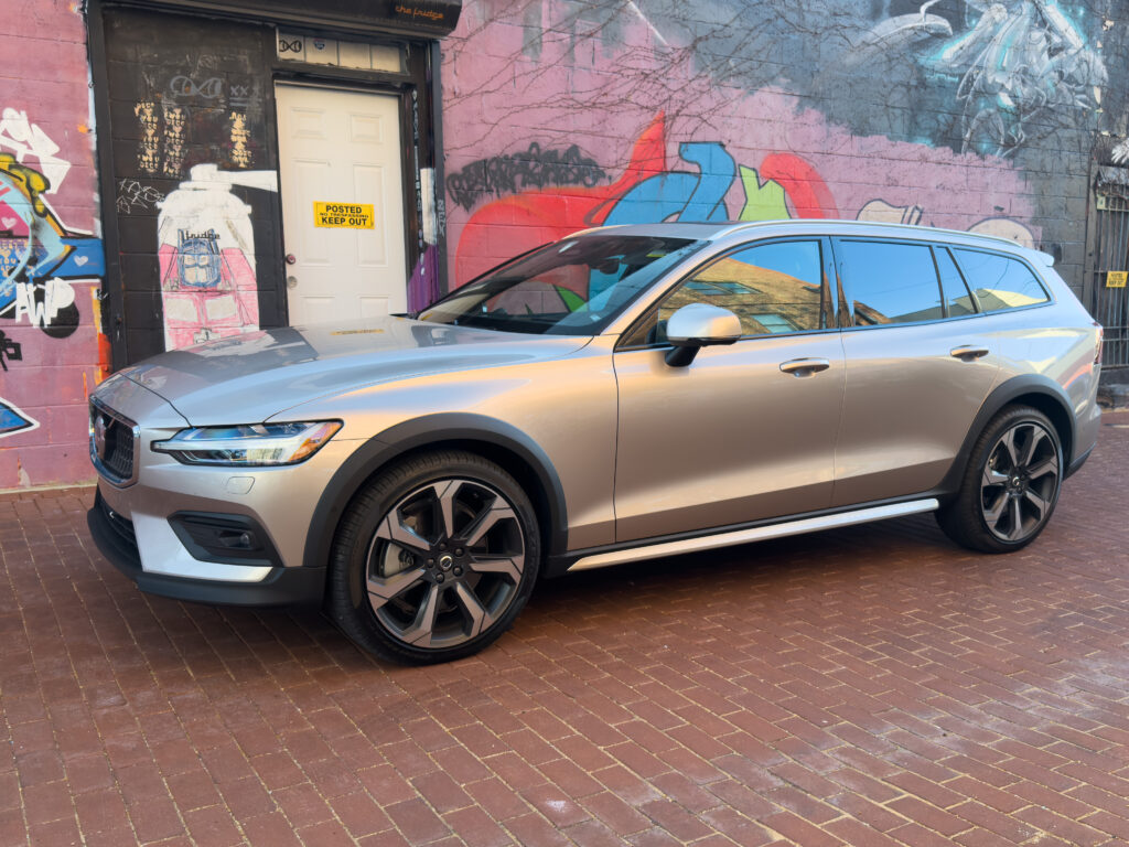 A Volvo V60 Cross Country parked in front of a mural, seen from the front 3/4s