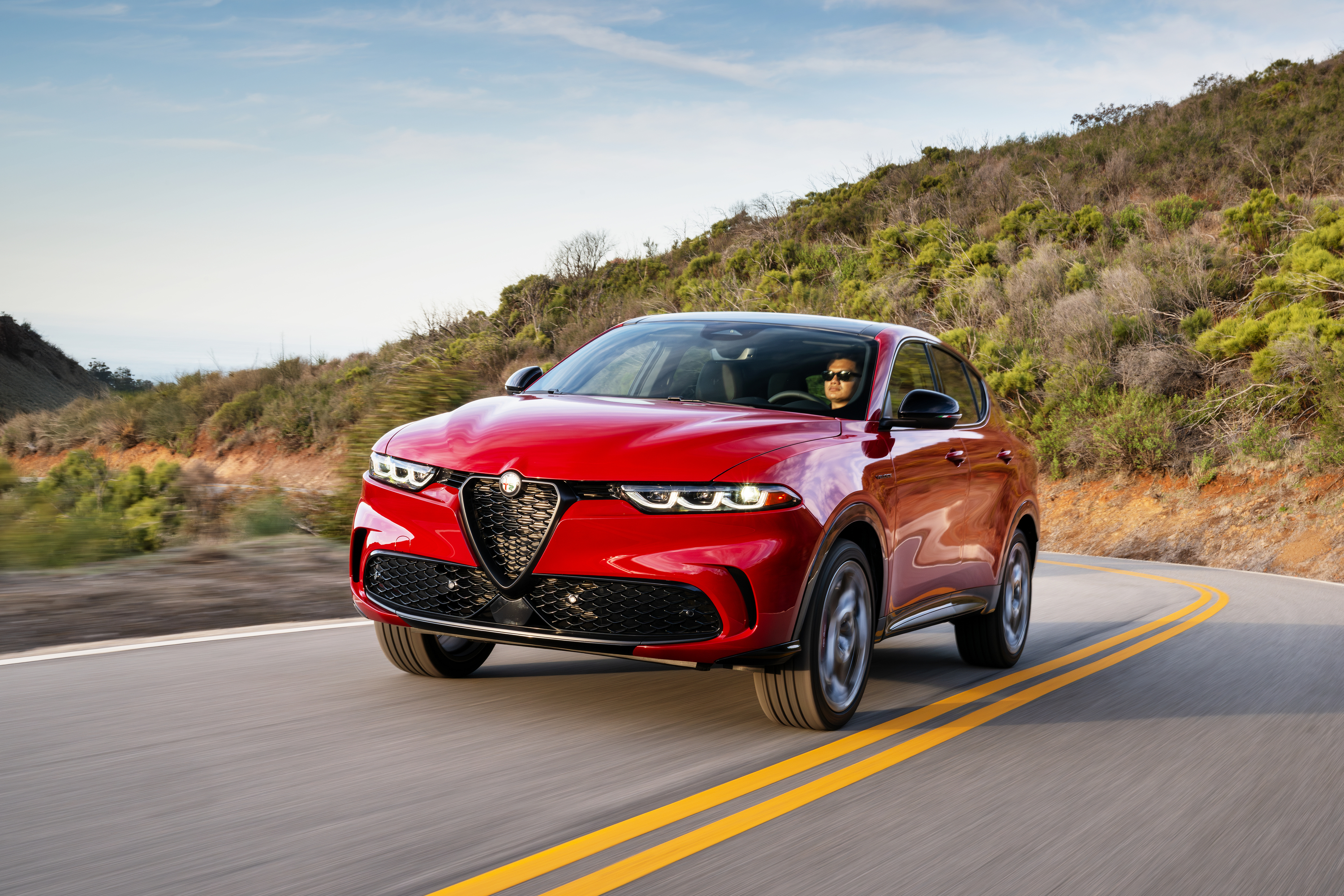 A red Alfa Romeo Tonale on a road