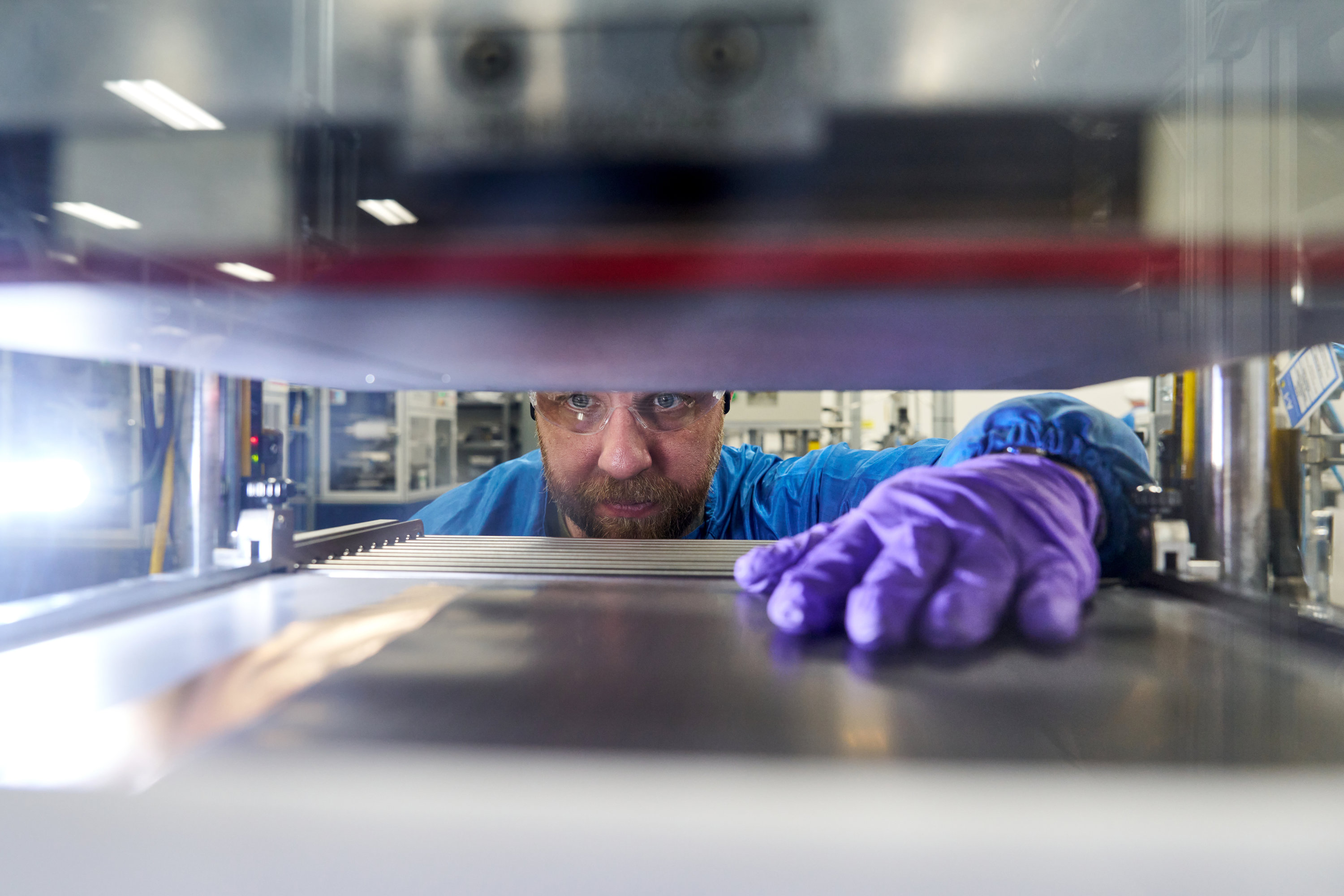 A man peers through a shelf in a lab