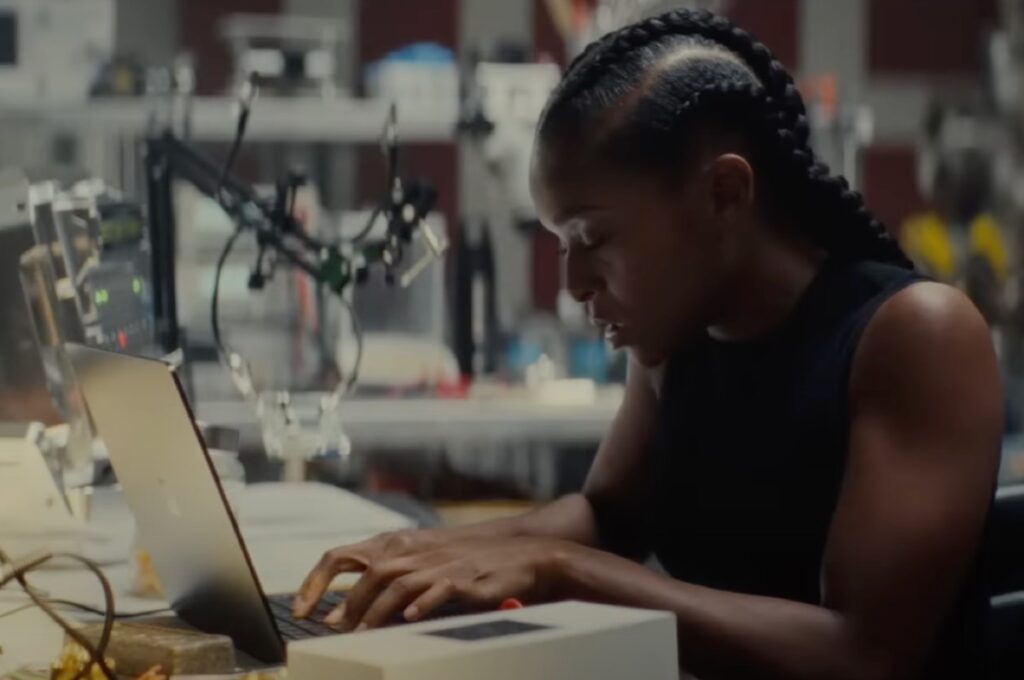 young black girl in a lab poring over data on a computer monitor