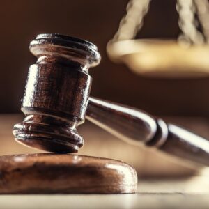 A judge's gavel with scales in the background.