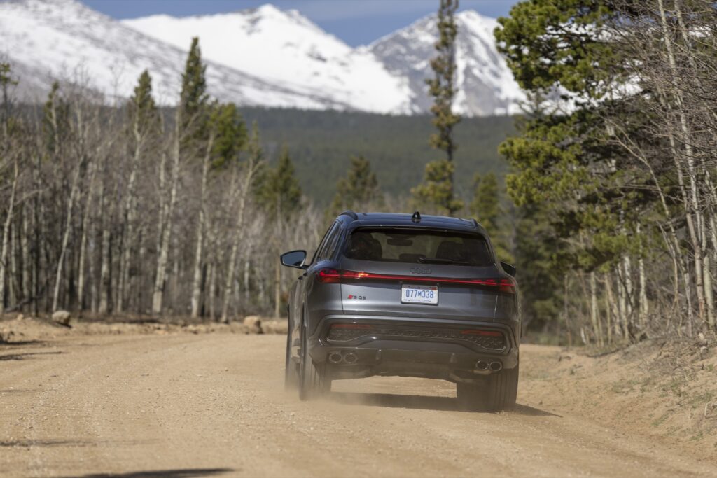 Audi SQ5 driving away from the camera on a dirt road