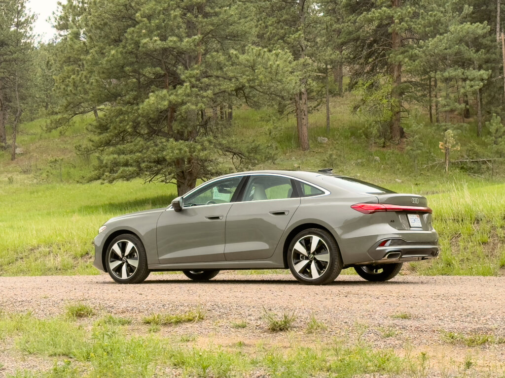 Audi A5 seen from the rear 3/4 view, with trees in the background