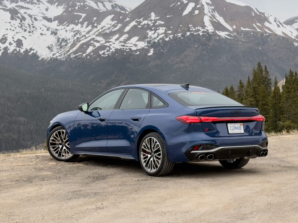 Audi S5 rear 3/4 view, with snowy mountains in the background.