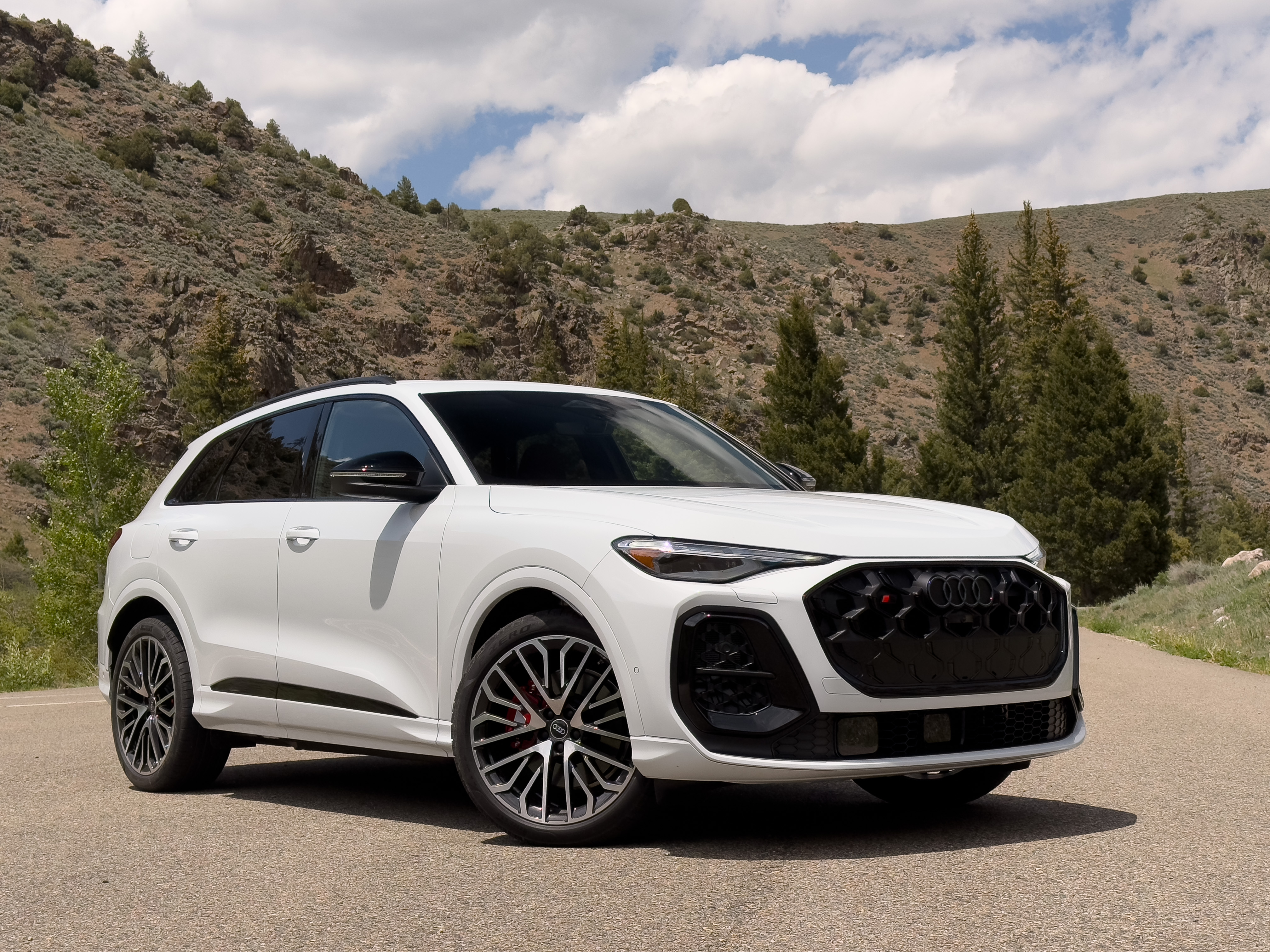A white Audi SQ5 parked in front of some mountains
