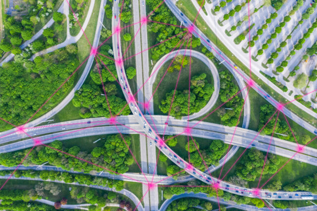 An overhead shot of a complicated highway junction, with data points connecting the cars.