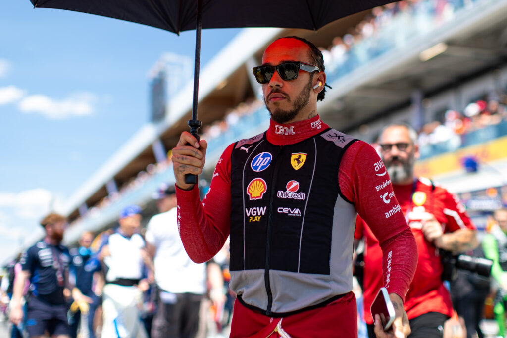 MONTREAL, CANADA - JUNE 15: Lewis Hamilton of Great Britain and Ferrari seeks shade under an umbrella in the pit lane during the F1 Grand Prix of Canada at Circuit Gilles-Villeneuve on June 15, 2025 in Montreal, Canada.
