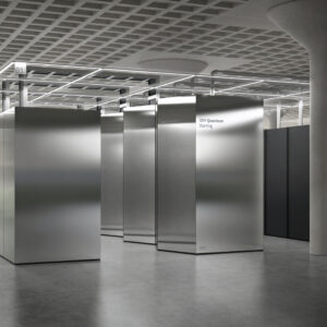A single room filled with large silver boxes connected by metal pipes.