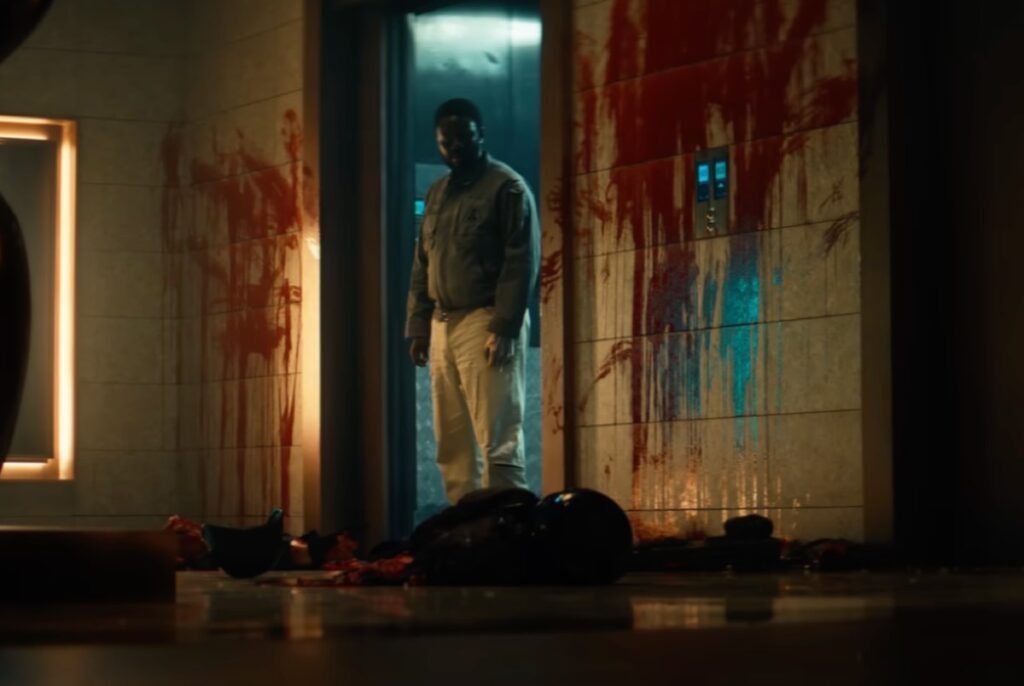 black man inside space ship looking in horror into a blood-soaked space.