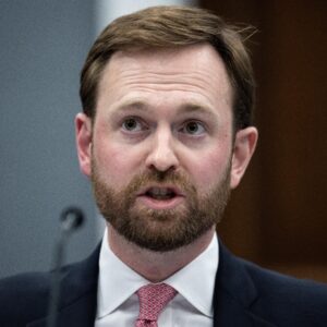 FTC Chairman Andrew Ferguson speaking into a microphone while sitting at a table.
