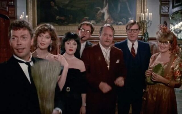 a group of people in dinner party fancy dress staring at the door.