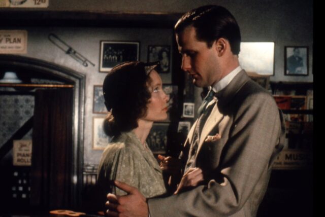 woman and a man in Depression-era garb gazing at each other in a loose embrace