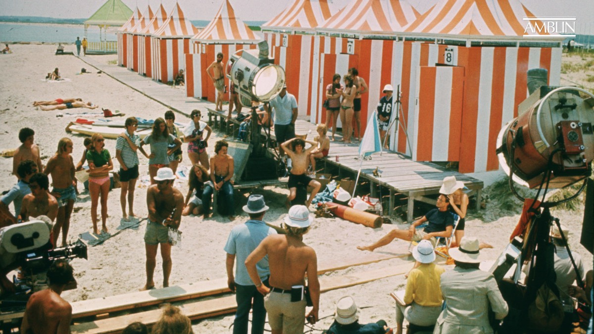 striped beach tents and throngs of people on a beach