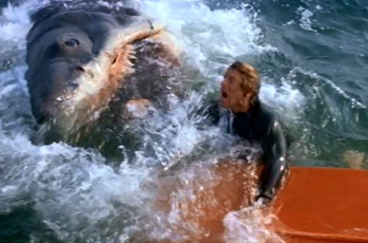 man flailing in agony in the water as he's being eaten by a mostly unseen shark.