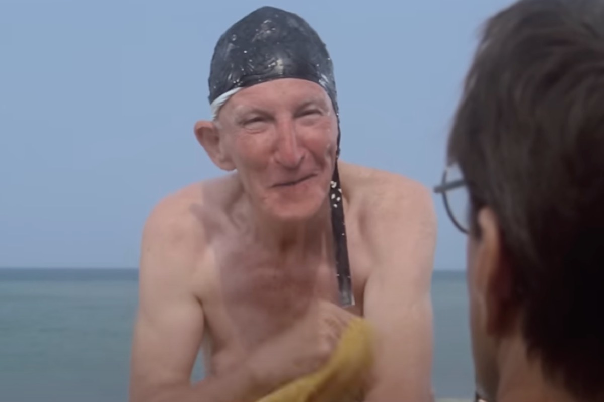 old man naked from waist up wearing an ugly swimming cap