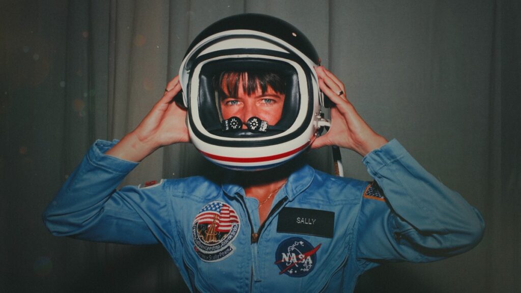 Sally Ride posing with her space helmet during her time in training as a mission specialist for NASA's STS-7 spaceflight.