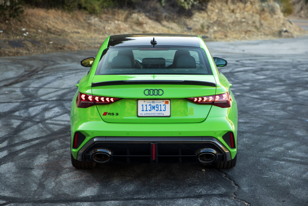 A green Audi RS3 facing away from the camera