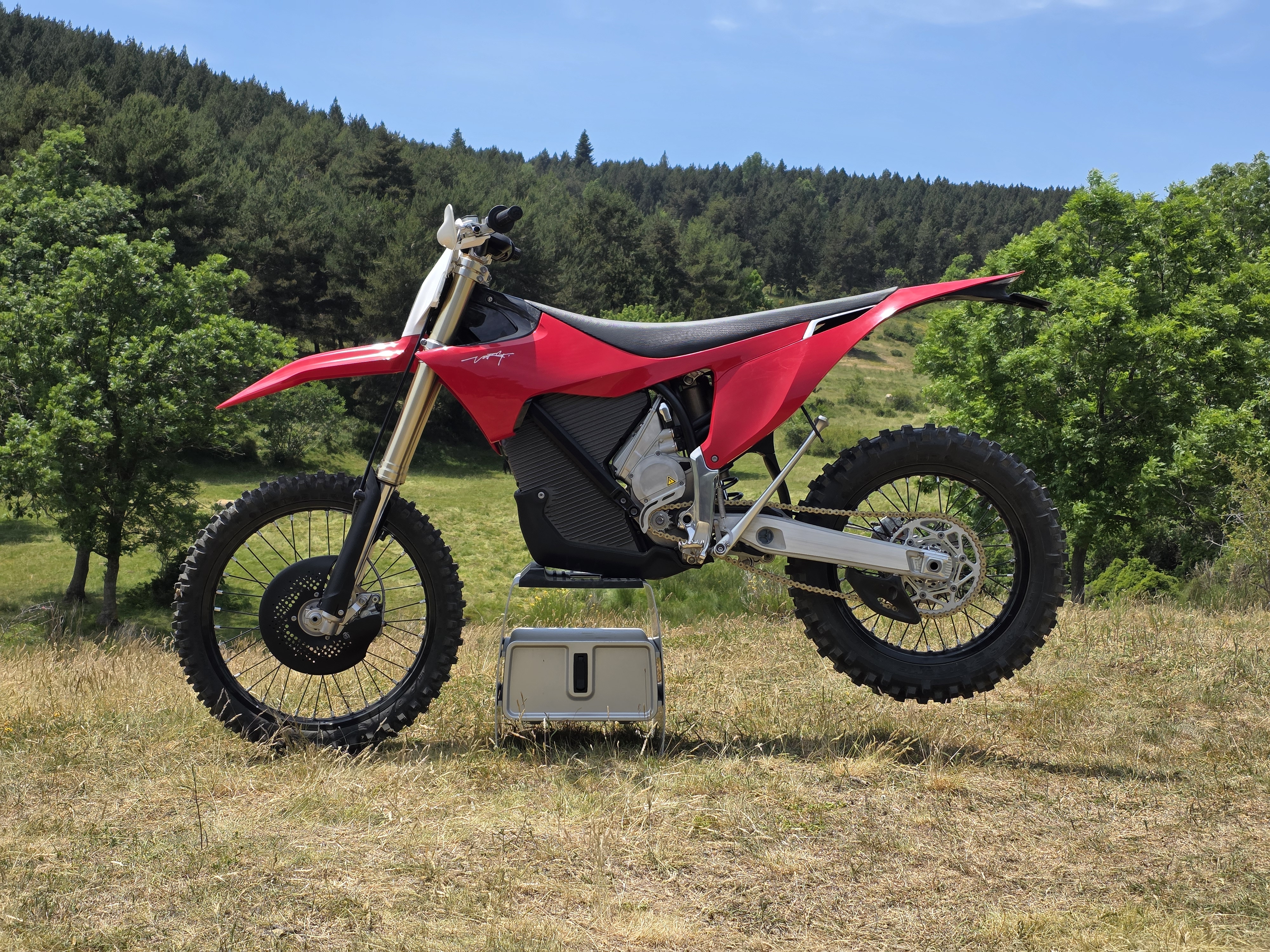 A Stark Varg EX motorbike on display in the wilderness.