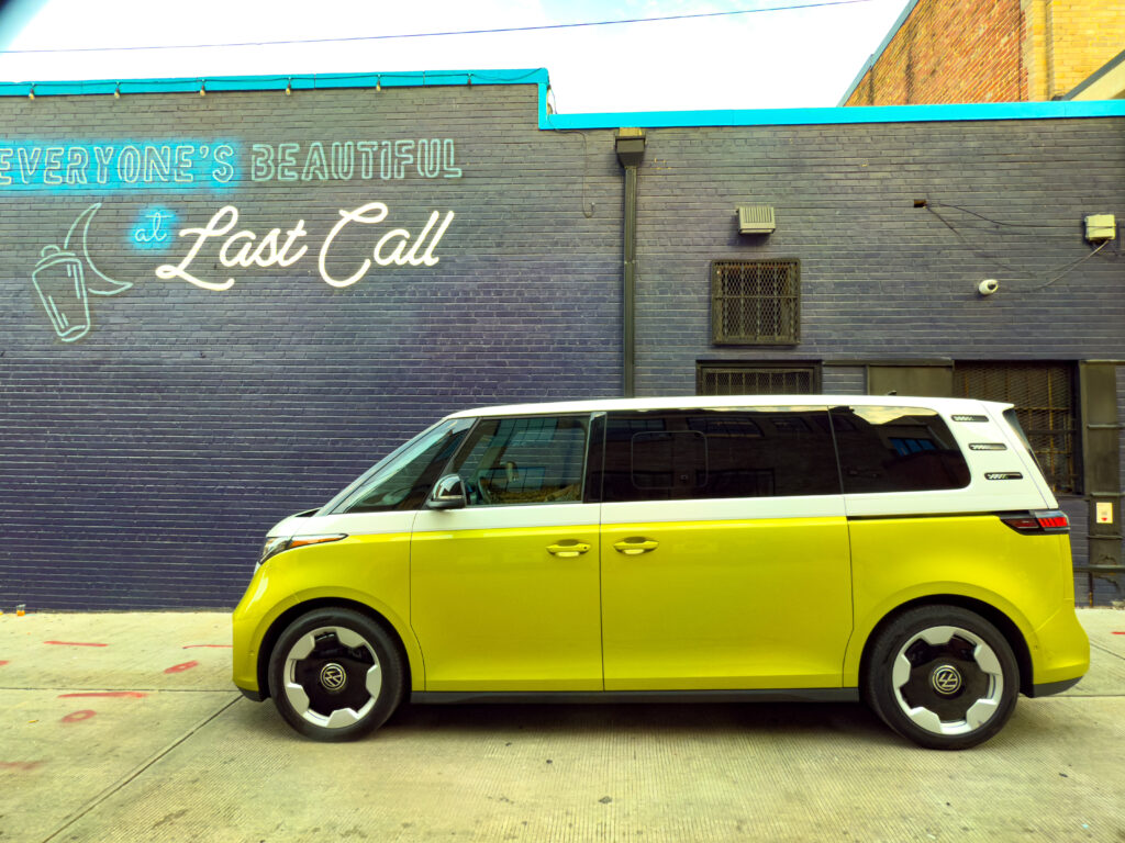 VW ID Buzz parked next to a blue-painted brick wall