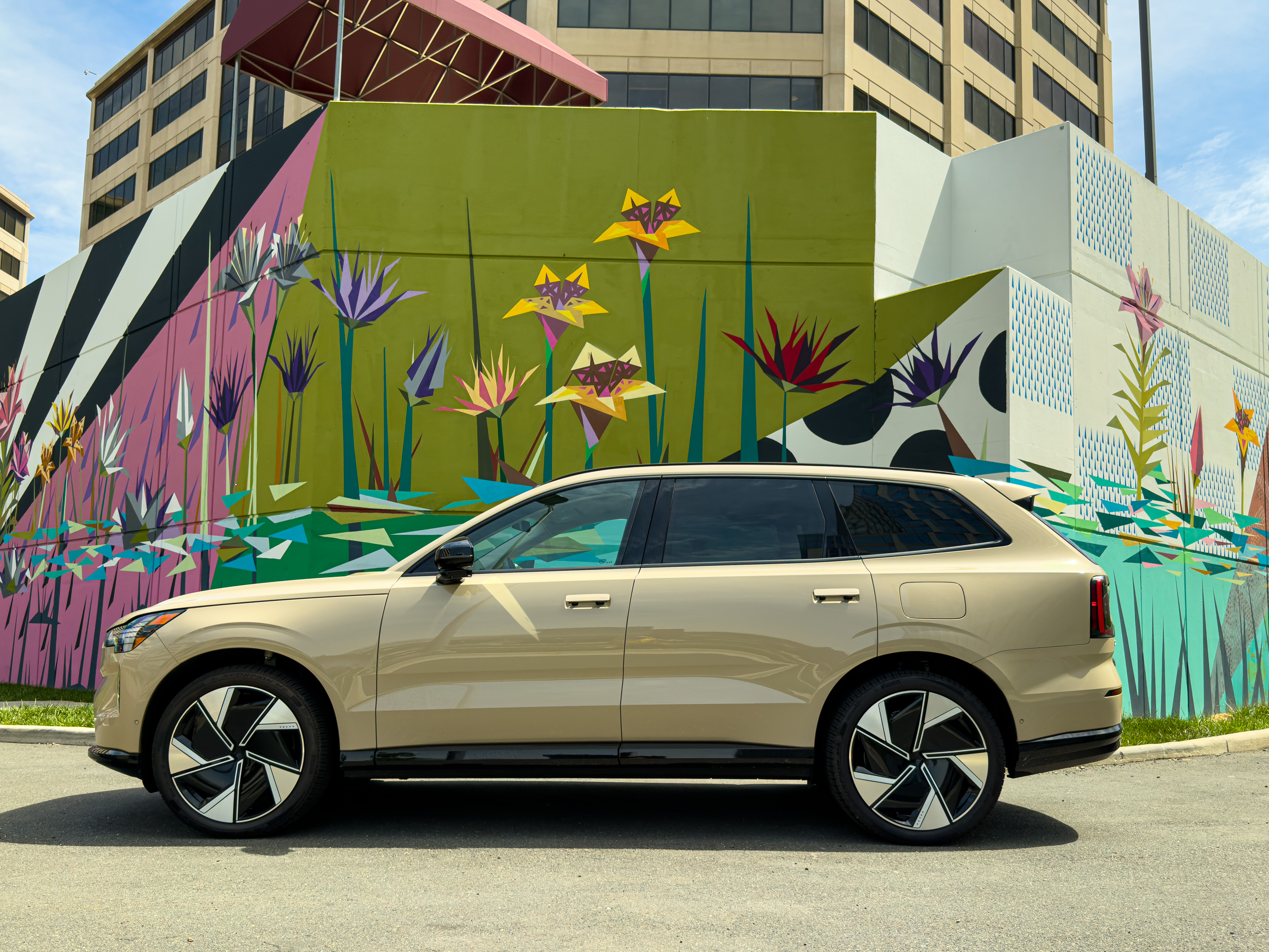 a Volvo EX90 in front of a colorful mural
