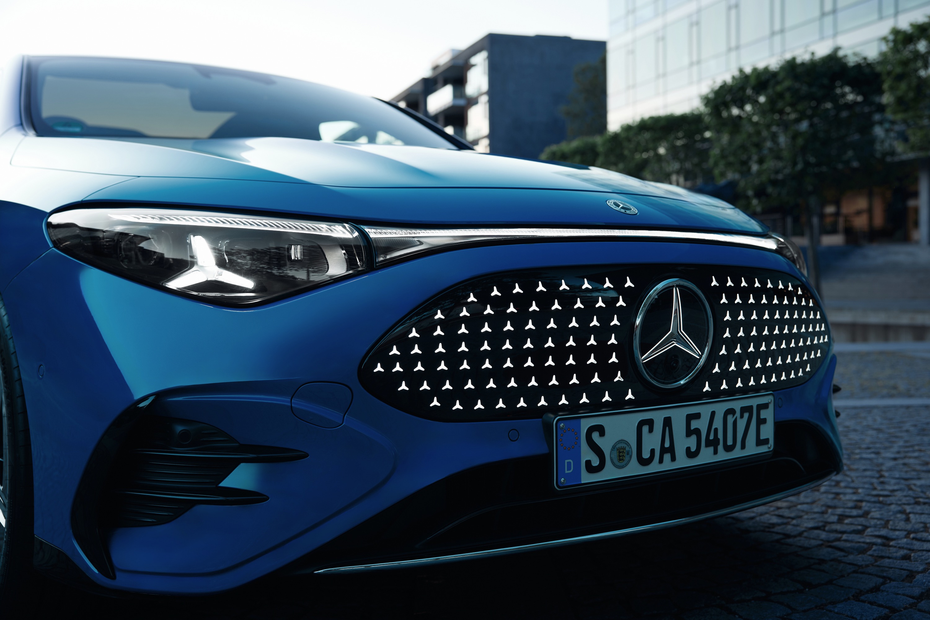 A closeup of the front of a blue Mercedes-Benz CLA with EQ technology.