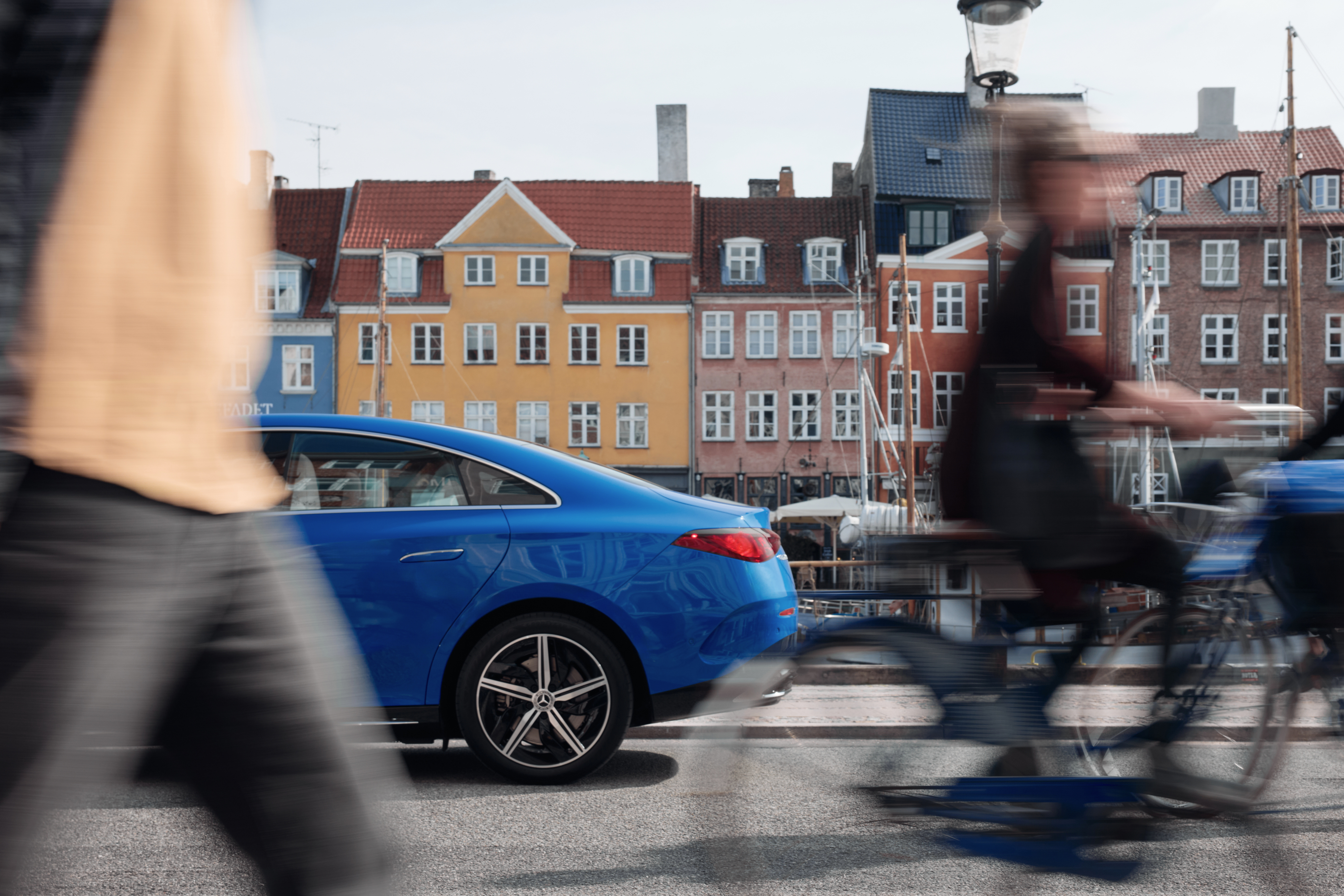 the back half of a Mercedes CLA seen with pedestrians and cyclists in the foreground.