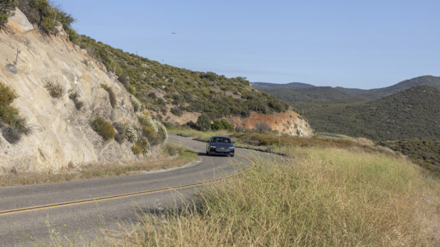 An Audi A6 drives in the countryside