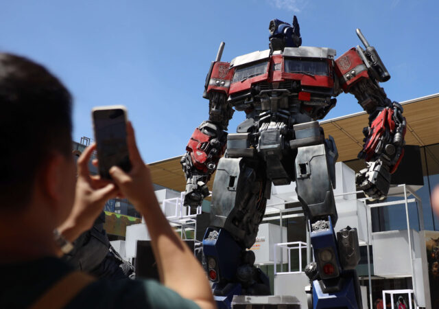 Photograph of a person taking a photograph of Optimus Prime