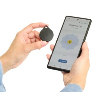 Someone holding a Pebblebee Clip Universal next to a smartphone showing the Pebblebee app.