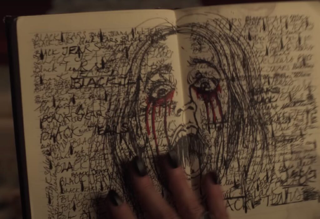 scrawled doodle of a girl with blood running from her eyes on the pages of an old notebook