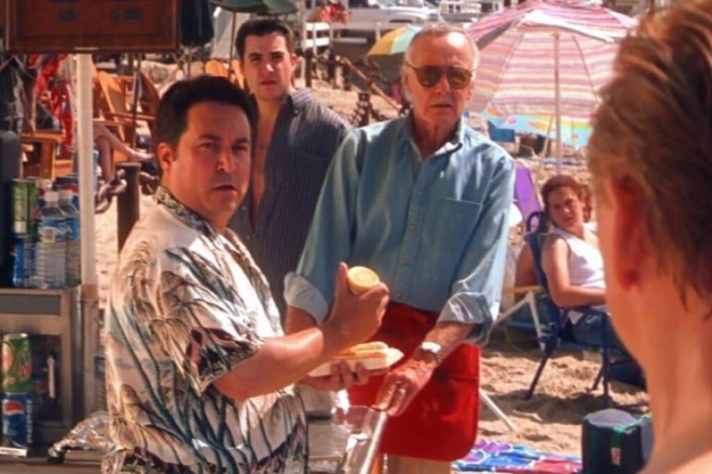 group of men on a beach at a concession stand staring and looking shocked