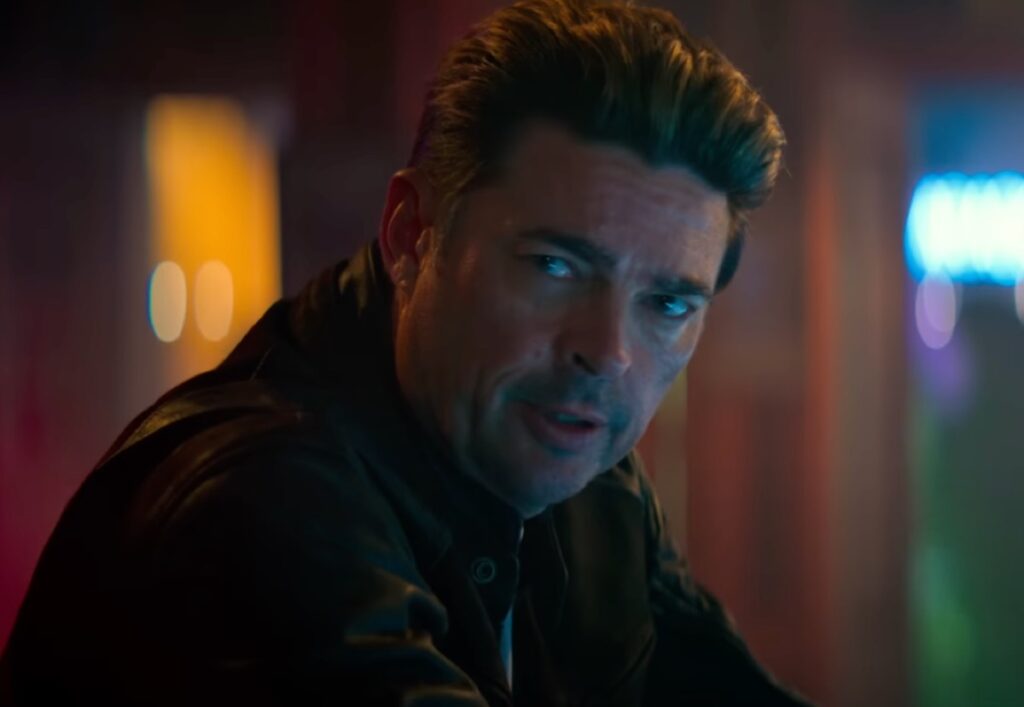 middle aged man with stubble drinking in a dive bar