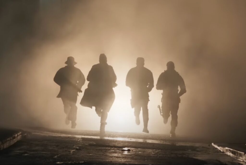 Four shadow armed figures running towards the camera,